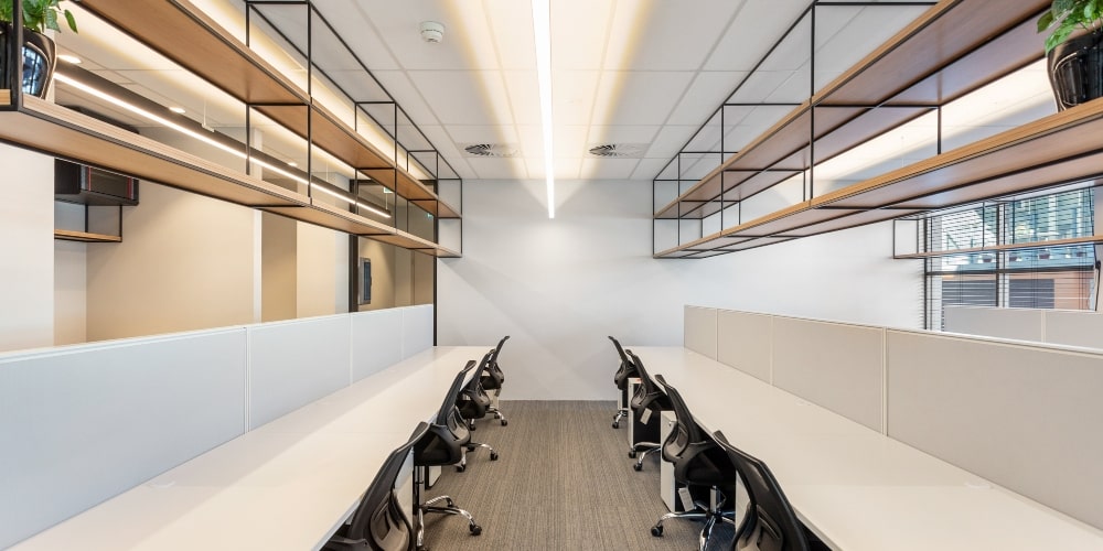 an office fitout with a row of modern desks and shelving