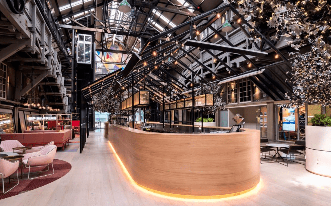 This unique hotel design in Australia showcases an angular cathedral ceiling which contrasts against a smooth rounded wooden bar.